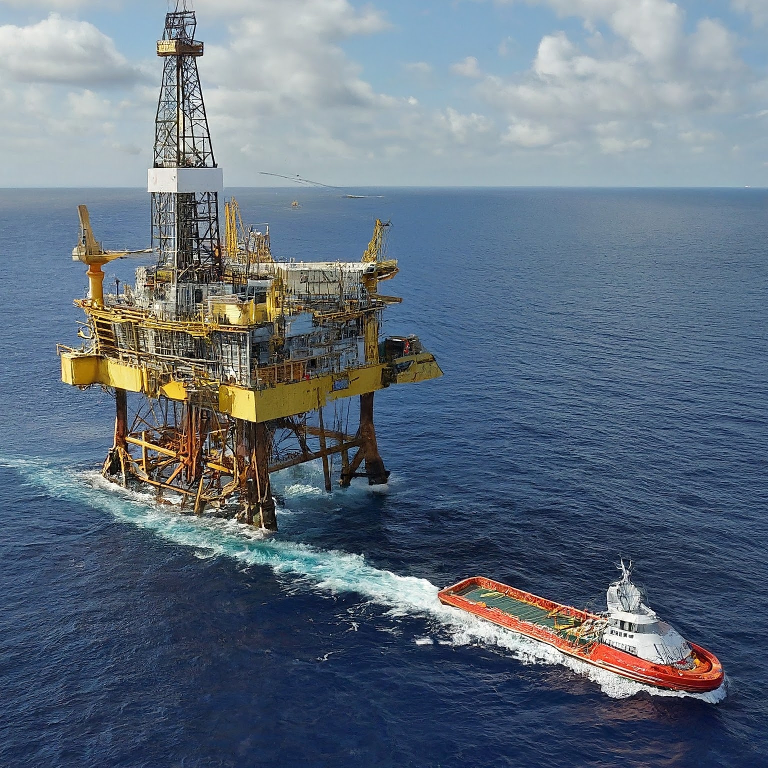 An oil rig with boat departing